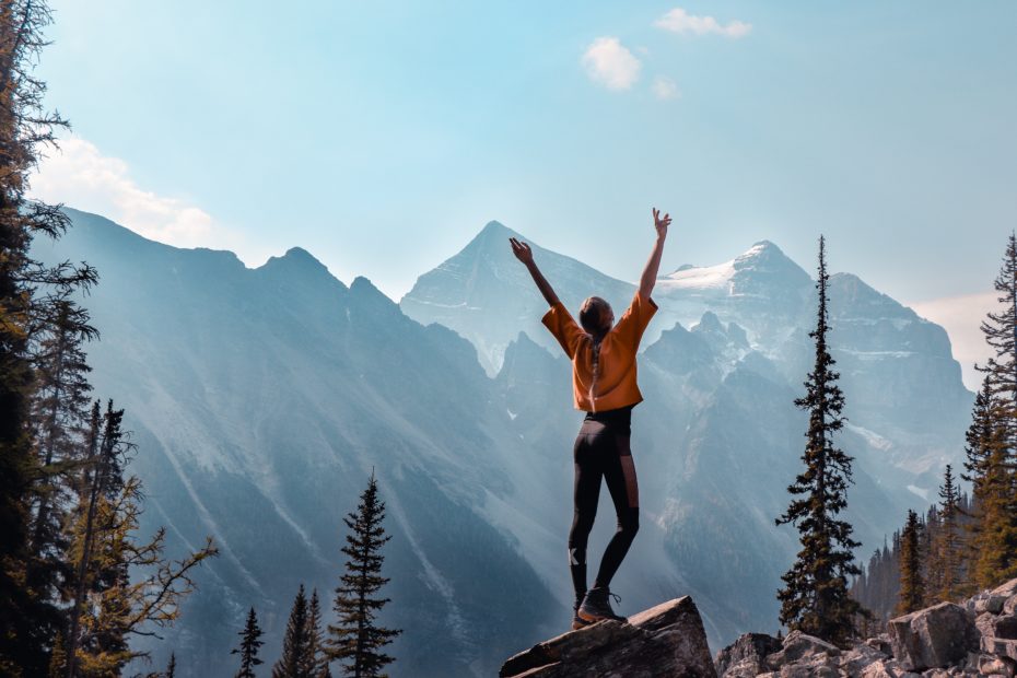 woman_hands_up_on_top_of_rock_in_the_woods